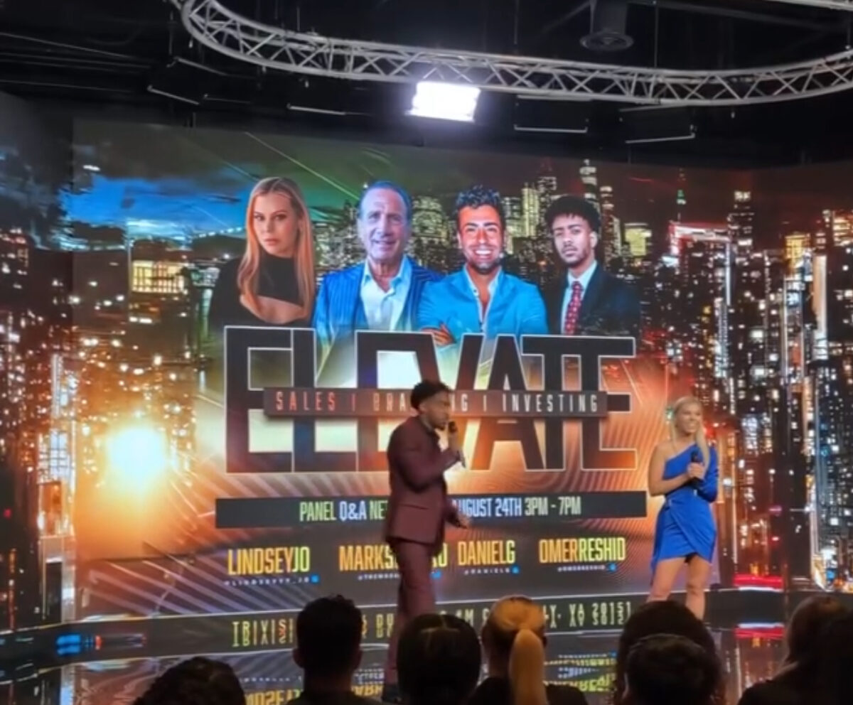 Professional event stage setup with a large LED screen displaying cityscape graphics, featuring hosts and panelists engaged in a corporate presentation or conference, showcasing high-quality audiovisual and event production services at TriVision Studios.