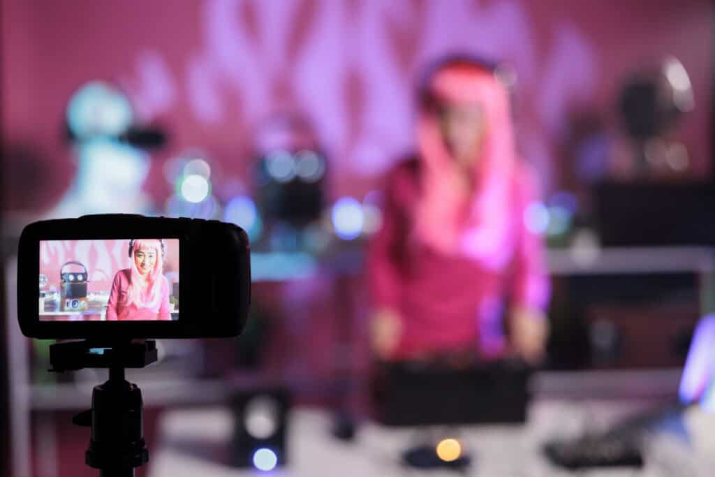 1. Female content creator recording video with professional camera, colorful and vibrant studio background with lighting effects, perfect for digital content production and creative media.