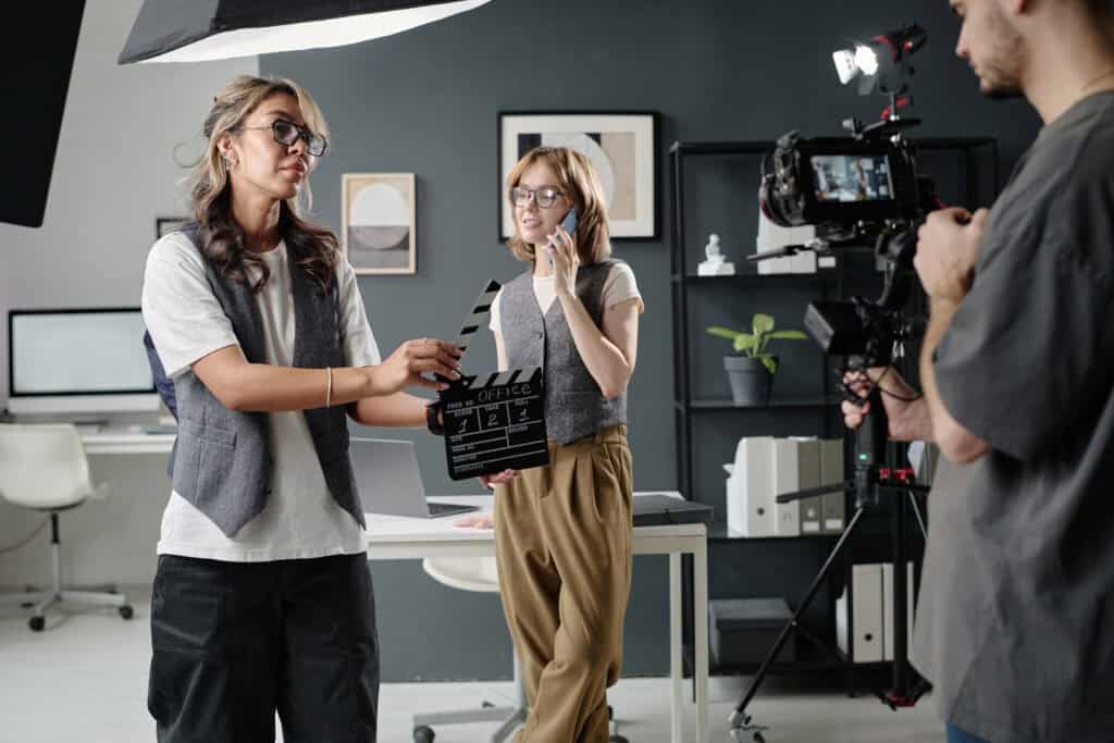 Professional video production team filming in a modern office setting, capturing high-quality content for corporate videos, with professional camera equipment and crew members engaged in the process.