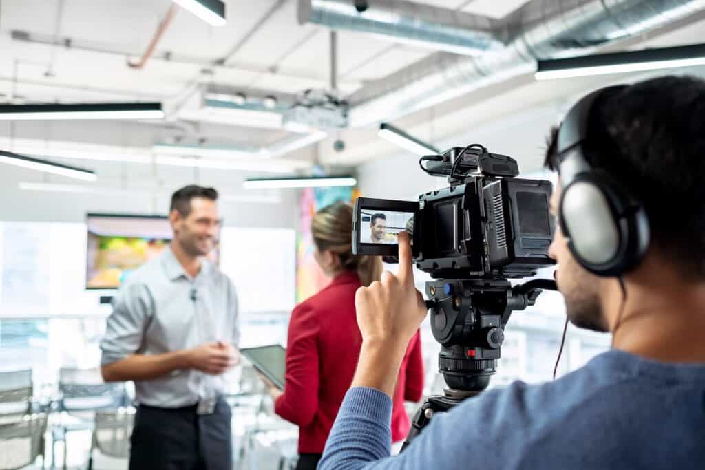 Camera setup capturing professional interview in bright modern studio environment.