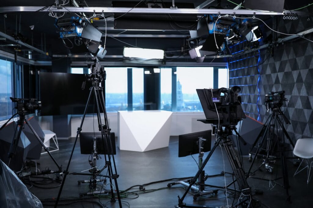Modern television studio with professional cameras and lighting for high-quality video production, showcasing advanced equipment and a sleek, contemporary design for broadcasting and media projects.