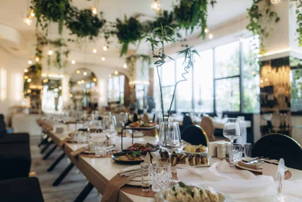 Spacious, stylish event space with well-set dining tables, floral centerpieces, and contemporary decor, ideal for upscale functions and private parties.