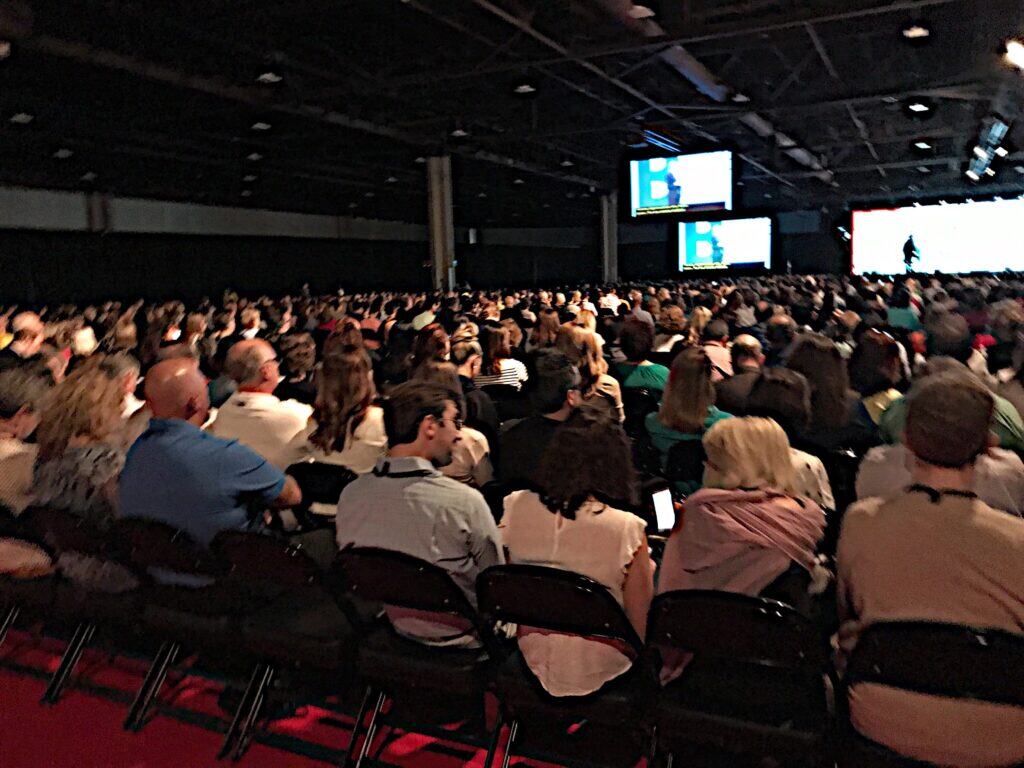 Vast conference hall filled with attentive audience during a professional event.