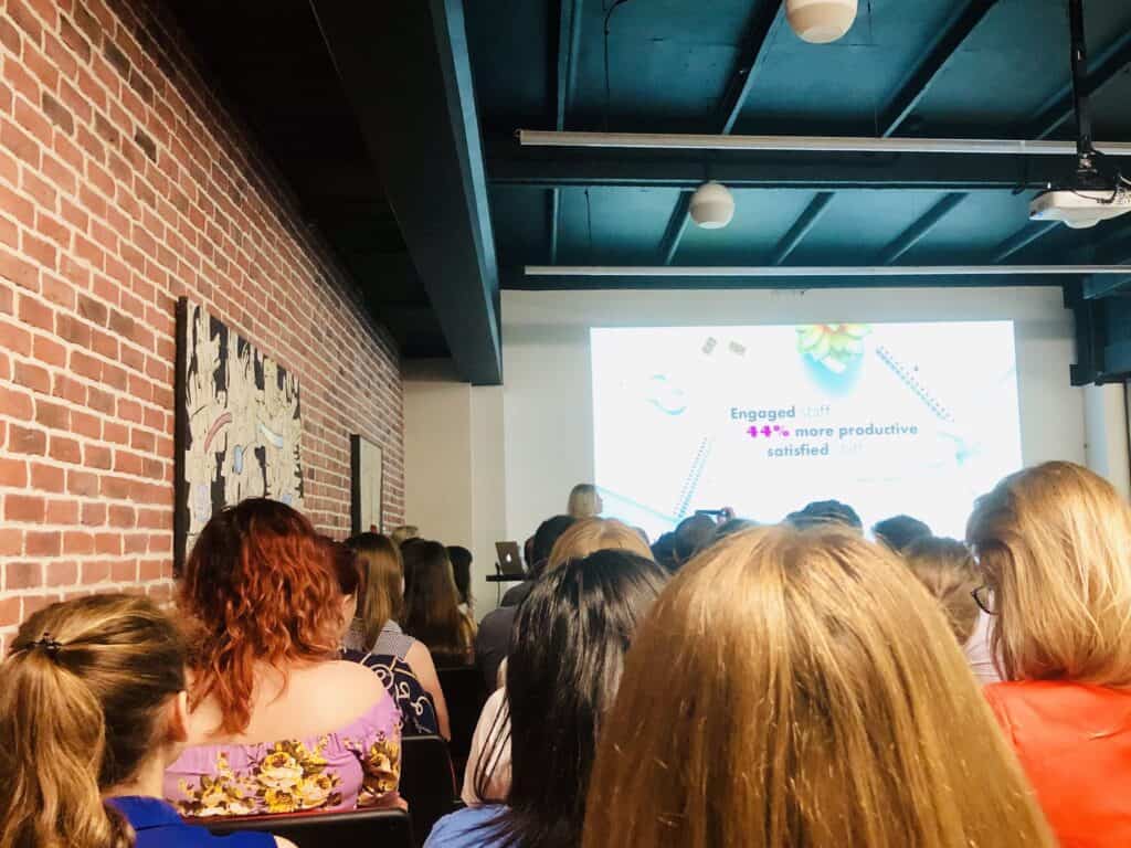 Modern corporate event space featuring a large screen and professional audio-visual setup perfect for meetings and seminars.