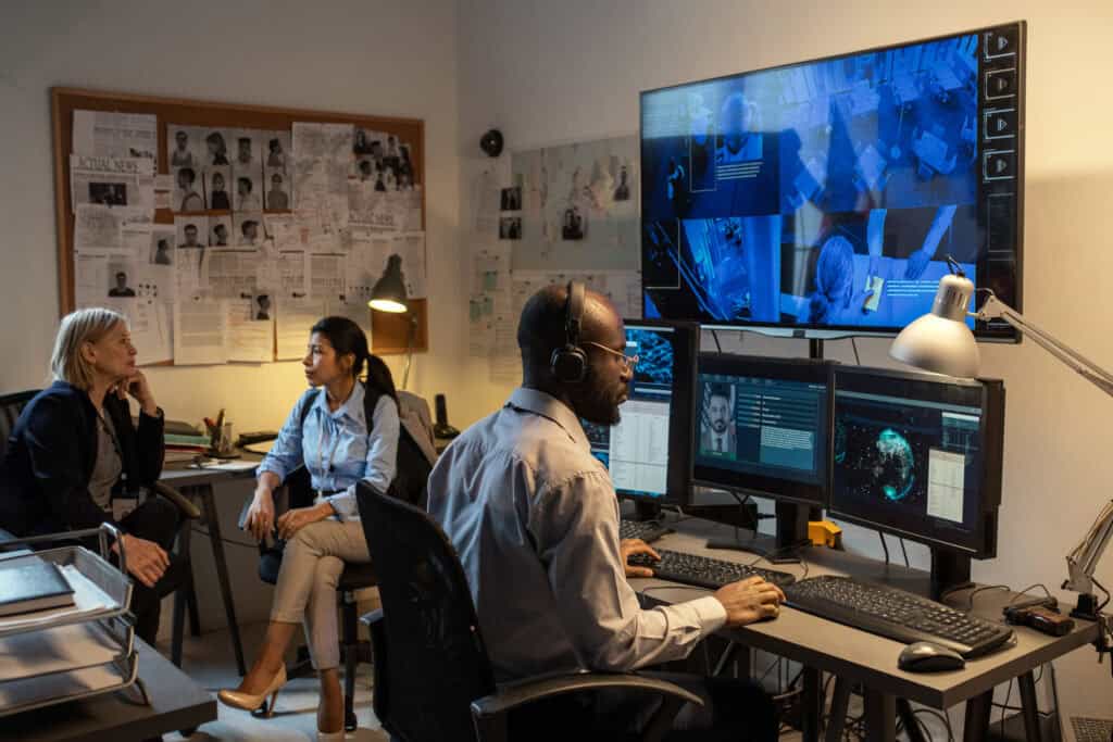 african american fbi agent sitting in front of com 2026 01 08 22 56 45 utc A diverse team collaborates in a high-tech office with multiple monitors displaying digital imaging and visual effects, showcasing professional video and media production at TriVision Studios.