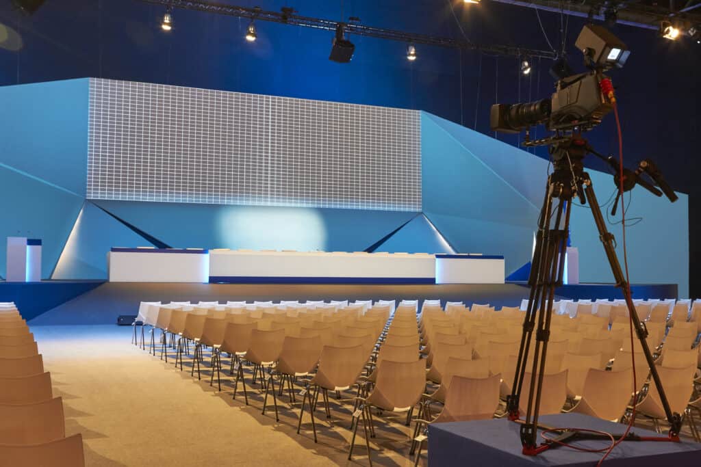 conference hall convention center with podium pr 2026 01 07 06 42 08 utc Modern conference stage setup with professional camera equipment and seating arrangement for events or presentations.